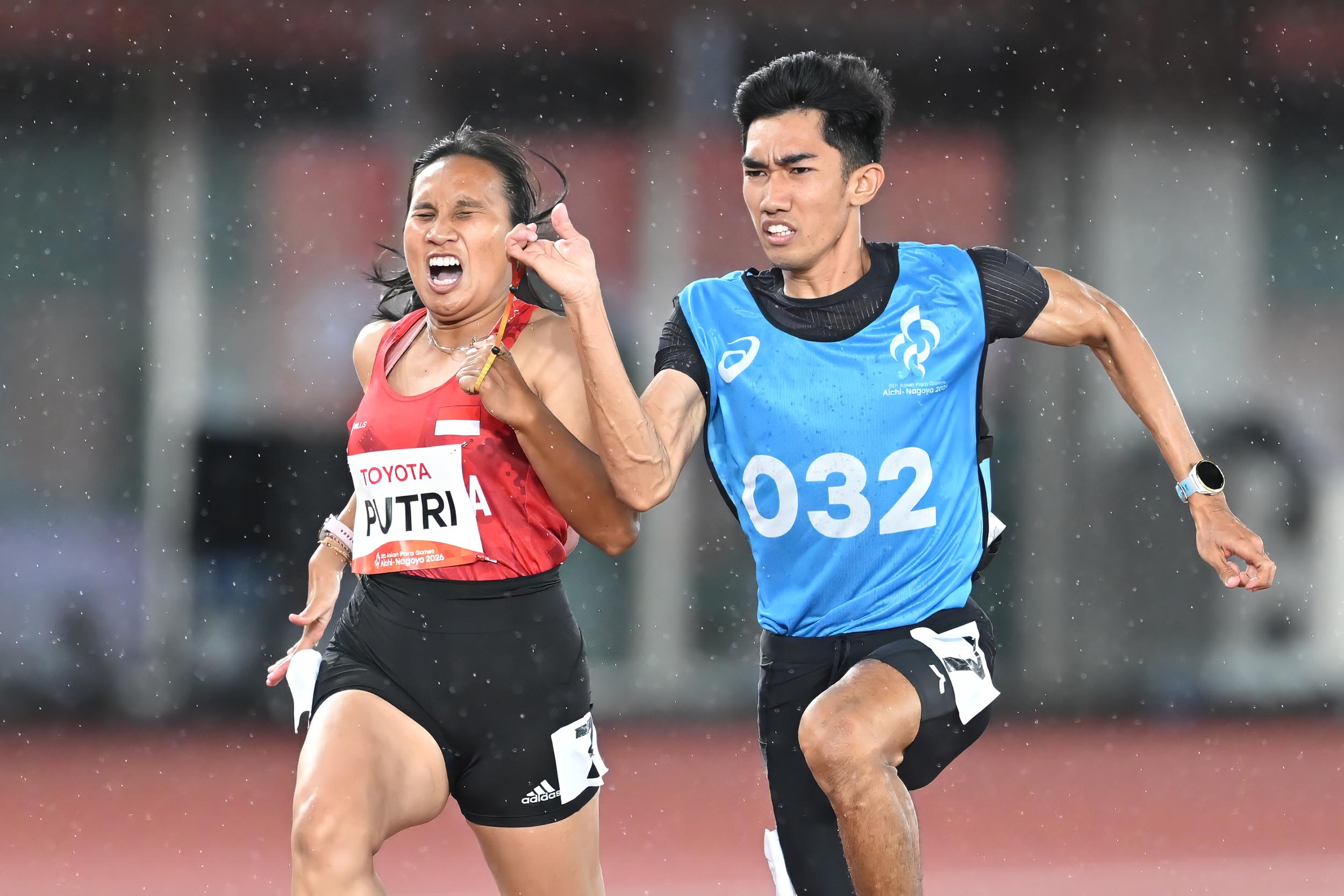 Sprinter Indonesia Ni Made Arianti (kiri) bersama pemandu larinya Guntur Widjanarko (kanan) memacu kecepatan dalam pertandingan para atletik nomor 100m T12 putri Asian Para Games 2026 di Nagoya City Mizuho Park Athletic Stadium, Nagoya, Jepang, Rabu (21/10/2026). Arianti berhasil meraih medali perunggu dengan catatan waktu 12,51 detik. NPC INDONESIA/Agung Wahyudi